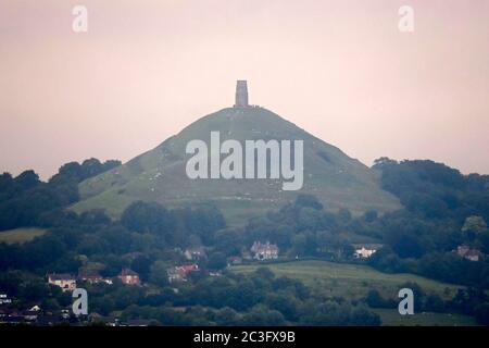 Glastonbury, Somerset, Großbritannien. Juni 2020. Wetter in Großbritannien. Viele Menschen versammelten sich auf dem Gipfel des Glastonbury Tor in Somerset, um den Sonnenaufgang über der Sommersonnenwende zu beobachten, aber der Himmel war bei Sonnenaufgang voller Wolken. Bildquelle: Graham Hunt/Alamy Live News Stockfoto