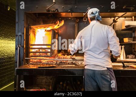 Koch kocht Fleisch und Würstchen auf dem Grill. Konzentrieren Sie sich auf Fleisch. Stockfoto