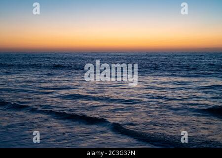 Bunte Dämmerung über dem tiefblauen Meer Stockfoto