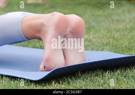 Weibliche Beine auf Yoga Matte Nahaufnahme Stockfoto