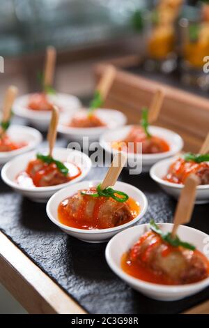 Köstliche Fleischbrötchen mit Sauce auf kleinen Tellern Stockfoto