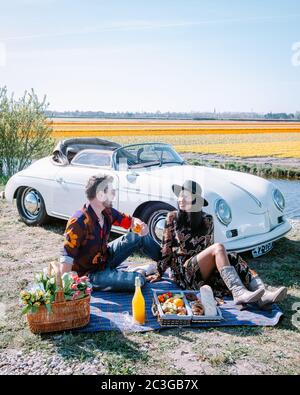 Lisse Niederlande ,. Paar tun eine Reise mit einem alten Vintage-Sportwagen White Porsche 356 Speedster, niederländische Blumenzwiebelregion Stockfoto
