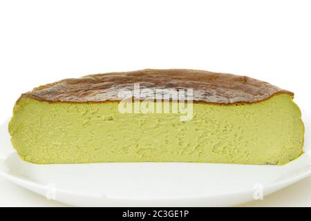 Halbe Tasse Matcha baskischen verbrannt Käsekuchen isoliert auf weißem Hintergrund. Stockfoto