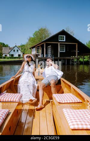 Giethoorn Niederlande Paar besuchen das Dorf mit einem Boot, Blick auf das berühmte Dorf mit Kanälen und rustikalen Strohdachhäusern i Stockfoto