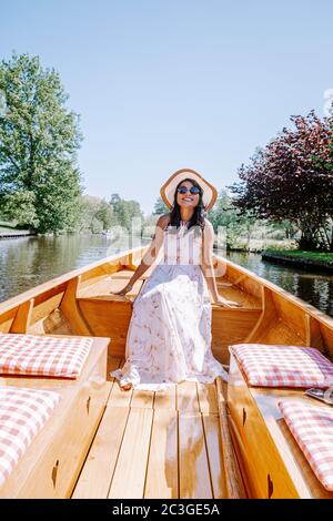 Giethoorn Niederlande Frau besuchen das Dorf mit einem Boot, Blick auf das berühmte Dorf mit Kanälen und rustikalen Strohdachhäusern in Stockfoto