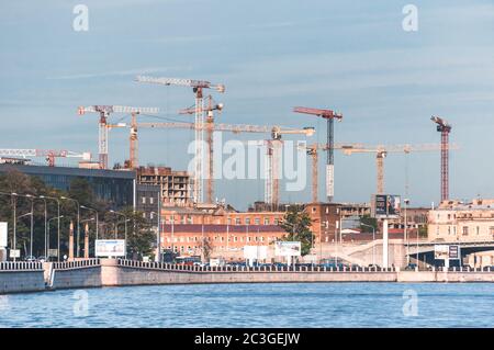 ST. PETERSBURG, RUSSLAND - 23. JULI 2019 - Stadtbild mit Neva Fluss und hohe Industriebaukrane auf Baustelle in Betrieb Stockfoto