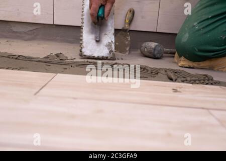 Handwerkzeug. Metallkelle mit quadratischen Zähnen ausgeschnitten. Ein Werkzeug zum Verkleben von Zement und Terrakotta mit Zementleim. Stockfoto