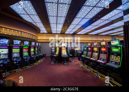 Halle im Casino ohne Menschen mit Spielautomaten und einer hellen Decke. Stockfoto