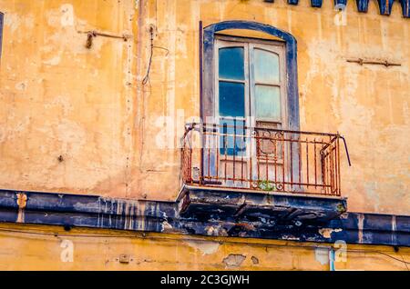 Vintage-Balkon an einer alten verlassenen und verfallenden Hausfassade in Italien Stockfoto