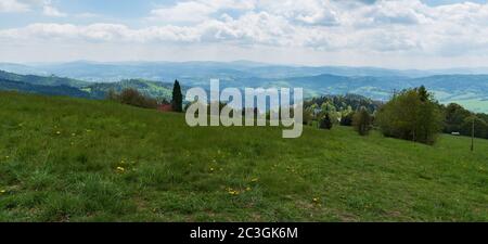 Blick von Bahenec im Frühling Slezske Beskiden in Tschechien mit einer Mischung aus Wiesen, Hügeln und blauem Himmel mit Wolken Stockfoto