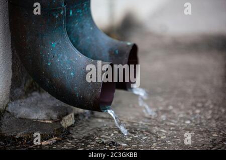 Wasser fällt aus den Dachrinnen Stockfoto