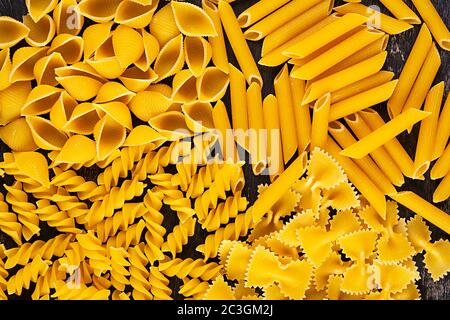 Verschiedene trockene Pasta auf einem Holzhintergrund. Draufsicht Stockfoto