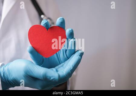 Rotes Herz aus Papier in den Händen eines Arzt Stockfoto