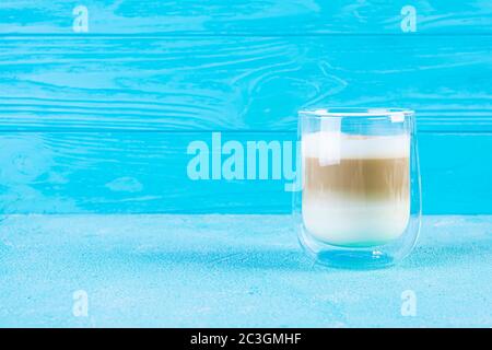 Tasse Kaffee Macchiato. Heißgetränk Kaffee auf blauem Hintergrund Stockfoto