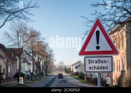 Verkehrsschild mit Warnung 'Straßenschaden' in deutscher Sprache Stockfoto