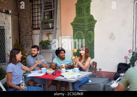 Gruppe von Studenten spielen in einer Lernpause in entspannter Atmosphäre mit Kaffee und Snacks Stockfoto
