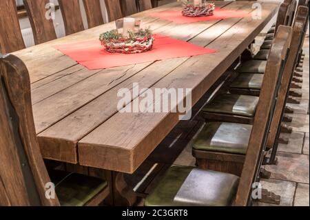 Riesiger Massivholztisch aus echtem Holz mit passendem Stühle im rustikalen Design Stockfoto