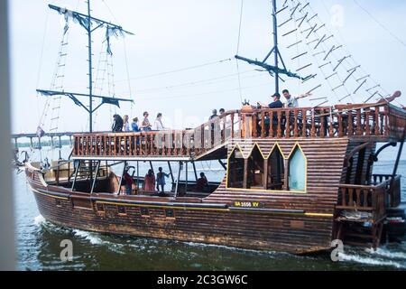 Piratenschiff mit Segelmasten und Motor verlässt den Hafen an einem sonnigen Tag in Dnepropetrovsk (Dnepr, Dnipro) Stadt, Ukraine, Dnepr Fluss. Stockfoto