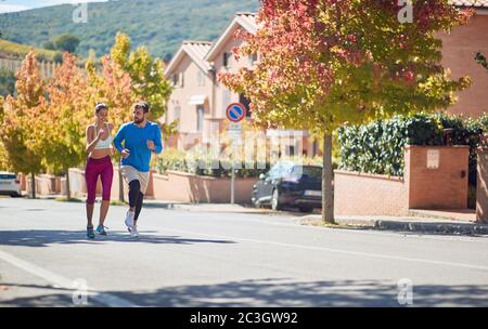 kaukasische bärtige männliche und Brünette weibliche Joggen zusammen Stockfoto