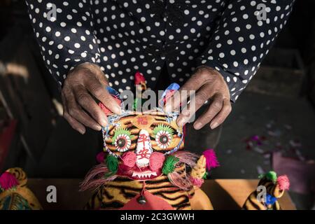 Hand hält einen Stofftiger Stockfoto