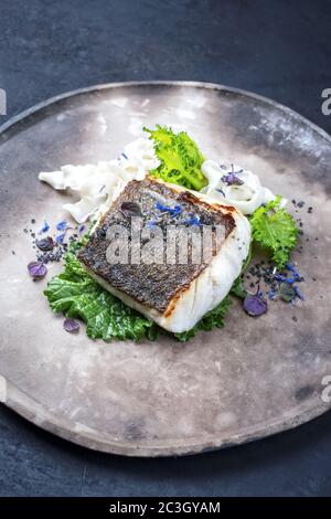 Gourmet-gebratenes europäisches Skrei-Kabeljau-Fischfilet mit Rapini-Brokkoli rabe und Nudeln als Nahaufnahme auf einem modernen Design-Teller Stockfoto