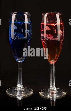 Vertikales Bild von zwei Champagnerflaschen mit Farben gegen ein Schwarzer Hintergrund Stockfoto