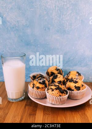 Schokoladenmuffins mit Milch. Tapete von Lebensmitteln mit Kopierraum und selektivem Fokus. Stockfoto