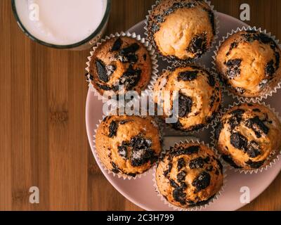 Schokoladenmuffins mit Milch. Tapete von Lebensmitteln mit Kopierraum und selektivem Fokus. Stockfoto