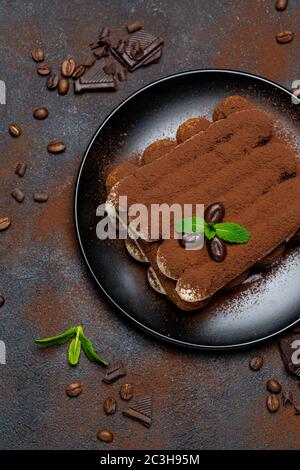 Klassisches Tiramisu Dessert auf Keramikplatte auf Betongrund Stockfoto