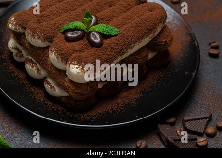 Klassisches Tiramisu Dessert auf Keramikplatte auf Betongrund Stockfoto