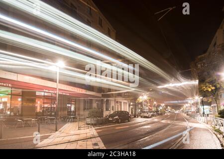 Nächtlicher Blick auf Grenoble, beleuchtet unter den französischen Alpen, mit Stadtlichtern, die die urbane Landschaft vor den dunklen Berglandschaften hervorheben. Stockfoto