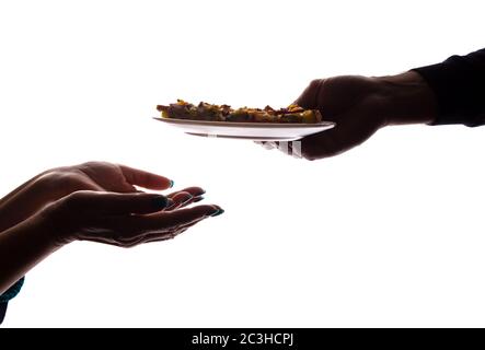 Junger Mann gibt einer älteren Frau in der Hand eine Pizza auf dem Teller - Silhouette, Hilfekonzept Stockfoto