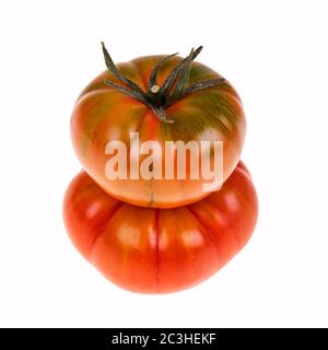 Zwei Erbstücke Marmande Tomaten in einem Stapel und isoliert auf weiß. Marmande sind eine kontinentale gerippte Sorte von Beefsteak-Tomaten. Stockfoto