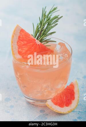 Grapefruit-Cocktail mit Eis und Rosmarin auf blauem Hintergrund. Frische, rohe Grapefruitscheiben. Makro Stockfoto