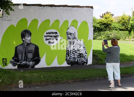 Eine Frau hält an, um das Wandbild der irischen Künstlerin Emmalene Blake mit den Figuren Marty McFly und Doc Brown aus dem Kult-80er-Film "Zurück in die Zukunft" in South Dublin zu fotografieren. Dies ist das neueste Coronavirus-Wandbild des Künstlers in Dublin während der Pandemie. Weitere Künstler waren Dua Lipa, Robyn und Cardi B. Stockfoto