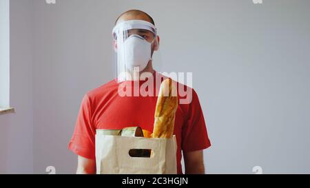 Portrait des Lieferers mit Maske während des covid-19. Stockfoto