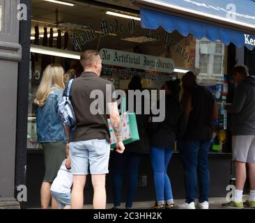 Beckenham, Großbritannien, 20. Juni 2020, die Menschen folgen den Regeln der sozialen Distanzierung, während sie Schlange stehen, um in die Geschäfte in Beckenham High Street, Kent zu gehen. Die Hauptstraße ist viel belebter, jetzt, da viele nicht wesentliche Geschäfte wieder geöffnet haben.Quelle: Keith Larby/Alamy Live News Stockfoto