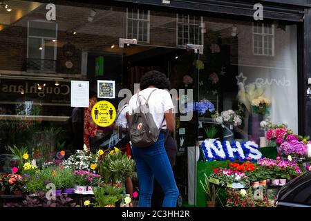 Beckenham, Großbritannien, 20. Juni 2020, die Menschen folgen den Regeln der sozialen Distanzierung, während sie Schlange stehen, um in die Geschäfte in Beckenham High Street, Kent zu gehen. Die Hauptstraße ist viel belebter, jetzt, da viele nicht wesentliche Geschäfte wieder geöffnet haben.Quelle: Keith Larby/Alamy Live News Stockfoto