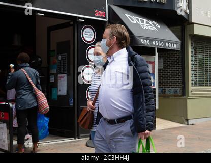 Beckenham, Großbritannien, 20. Juni 2020, die Menschen folgen den Regeln der sozialen Distanzierung, während sie Schlange stehen, um in die Geschäfte in Beckenham High Street, Kent zu gehen. Die Hauptstraße ist viel belebter, jetzt, da viele nicht wesentliche Geschäfte wieder geöffnet haben.Quelle: Keith Larby/Alamy Live News Stockfoto