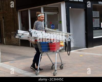 Beckenham, Großbritannien, 20. Juni 2020,EIN Mann geht mit einem Einkaufswagen voller Leitern und Taschen in Beckenham High Street, Kent. Die Hauptstraße ist viel belebter, jetzt, da viele nicht wesentliche Geschäfte wieder geöffnet haben.Quelle: Keith Larby/Alamy Live News Stockfoto