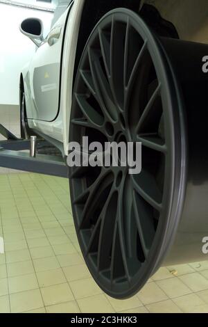 Moskau. Februar 2019. Weißes Porsche 911 Cabriolet am Lift im Service Center. Austausch der Räder. Reifenmontage. Schwarze, matte Custom-Räder Stockfoto
