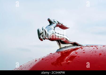 Moskau, Russland - 25. Mai 2019: Ein Hirsch auf der roten Haube eines Gaz-21 Wolga Autos gegen den Himmel. Russisches Retro-Auto Stockfoto