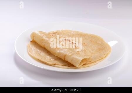 Hausgemachtes Kerala Parotta/ Porotta /Paratta /geschichtetes Fladenbrot mit maida oder raffiniertem Mehl oder Allzweckmehl, das wunderschön auf einem weißen Teller angeordnet ist Stockfoto