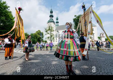 Lowicz, 11. Juni 2020: Menschen in polnischen Volkstrachten aus der Region Lowicz und Gesicht Schutzmasken während Fronleichnam Prozession. Stockfoto