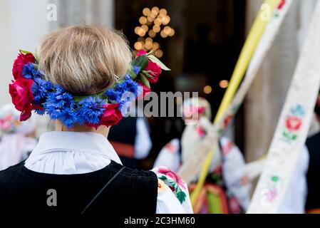 Frau mit Blumenkränz, in polnischer Volkstracht von Lowicz gekleidet. Traditionelle bunte Volkskleid. Rückansicht des Kopfbügels mit Blumenmuster Stockfoto