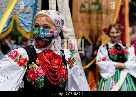 Lowicz, 11. Jun 2020: Portrait einer Frau in polnischer Volkstracht aus Lowicz und Gesichtsschutzmaske während der Fronleichnamsprozession Stockfoto