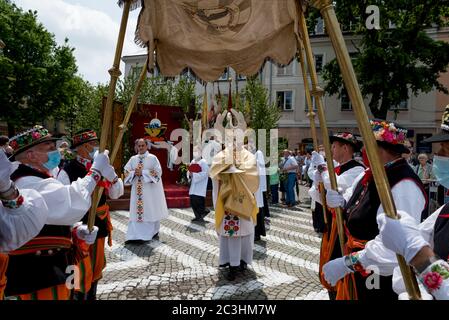 Lowicz, 11. Juni 2020: Jährliche Fronleichnamsprozession. Priester hält Monstranz. Menschen in polnischen Volkstrachten aus Lowicz Stockfoto