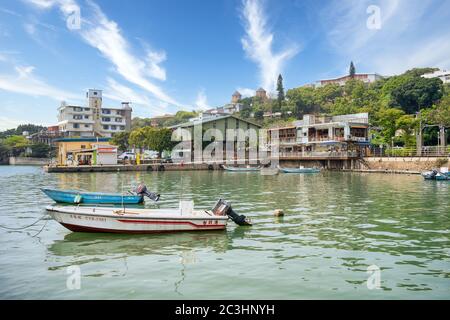 Kleine Motorboote in einem kleinen Fischerhafen in Tamsui (Danshui), Taipei, Taiwan mit blauem Himmel Stockfoto