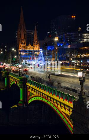 MELBOURNE, AUSTRALIEN - 8. Dezember 2019 - Langzeitbelichtung einer Weihnachtsprojektion auf einer belebten Princes Bridge in Melbourne, Stockfoto