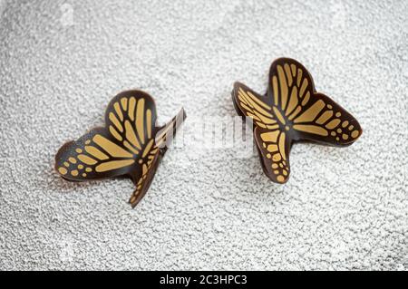 Schokolade Schmetterlinge auf einem Hintergrund von weißem Schokolade Eis Stockfoto